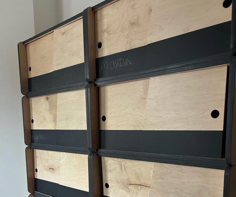 Martin Beugeling and Aymen Chargui marked their names with chalk on their dry-goods kitchen storage containers. The other containers have yet to be claimed in the still mostly empty building. (Photo by Aaron Wiener/The Washington Post)