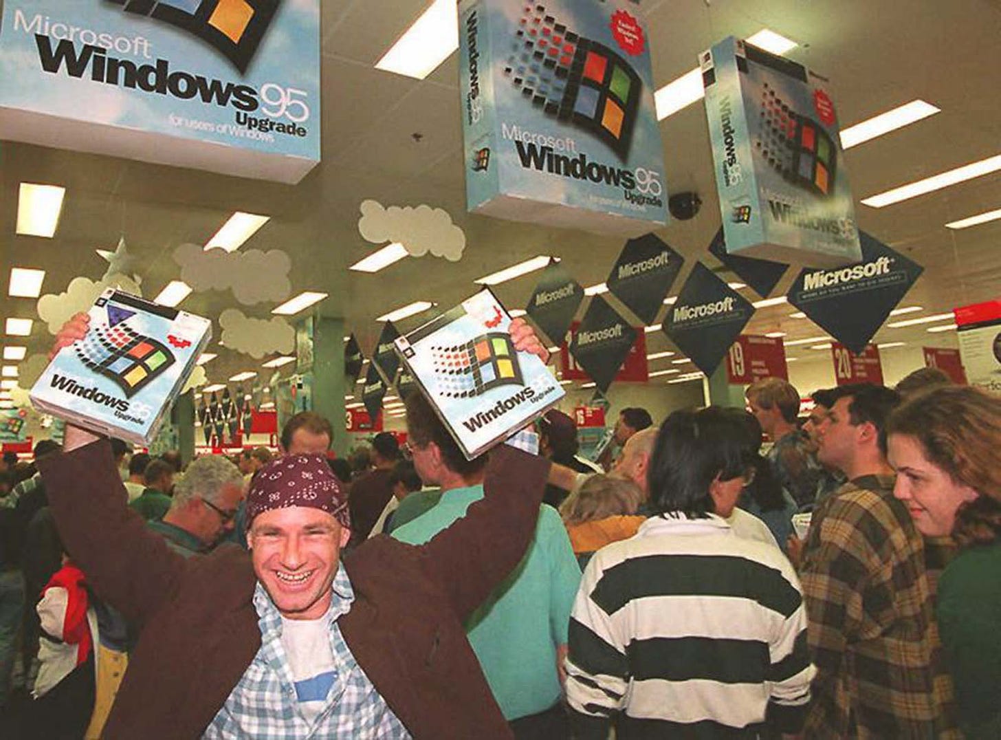 Mikol Furneaux waves two copies of Windows 95 at a midnight launch at a store in Sydney, Australia.