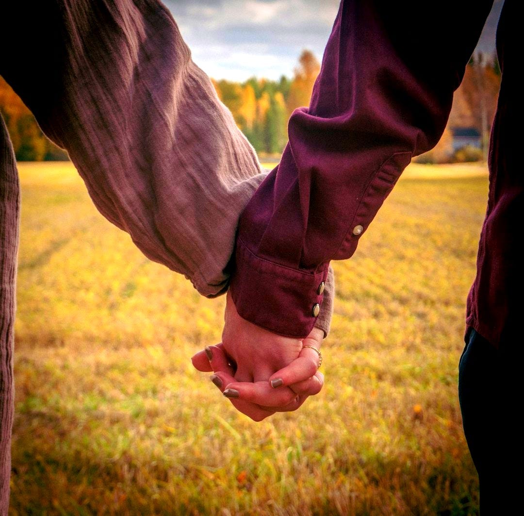 a man and woman holding hands in a field a man and woman holding hands in a field