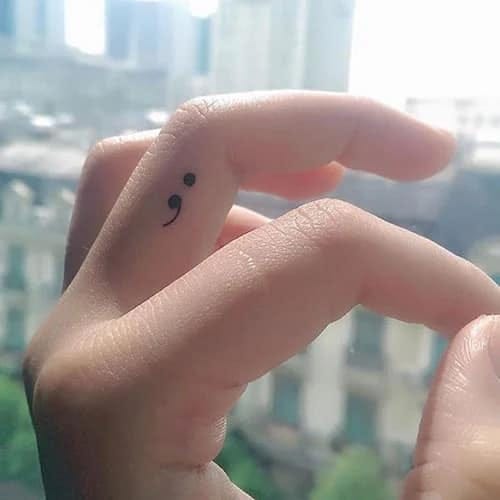 semicolon tattoo on side of finger