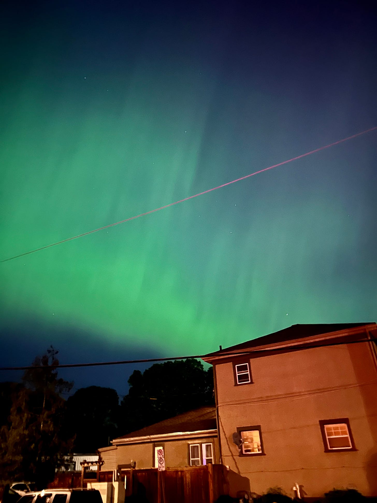 Bluish-green Northern Lights in the sky over a neighbourhood in London ON