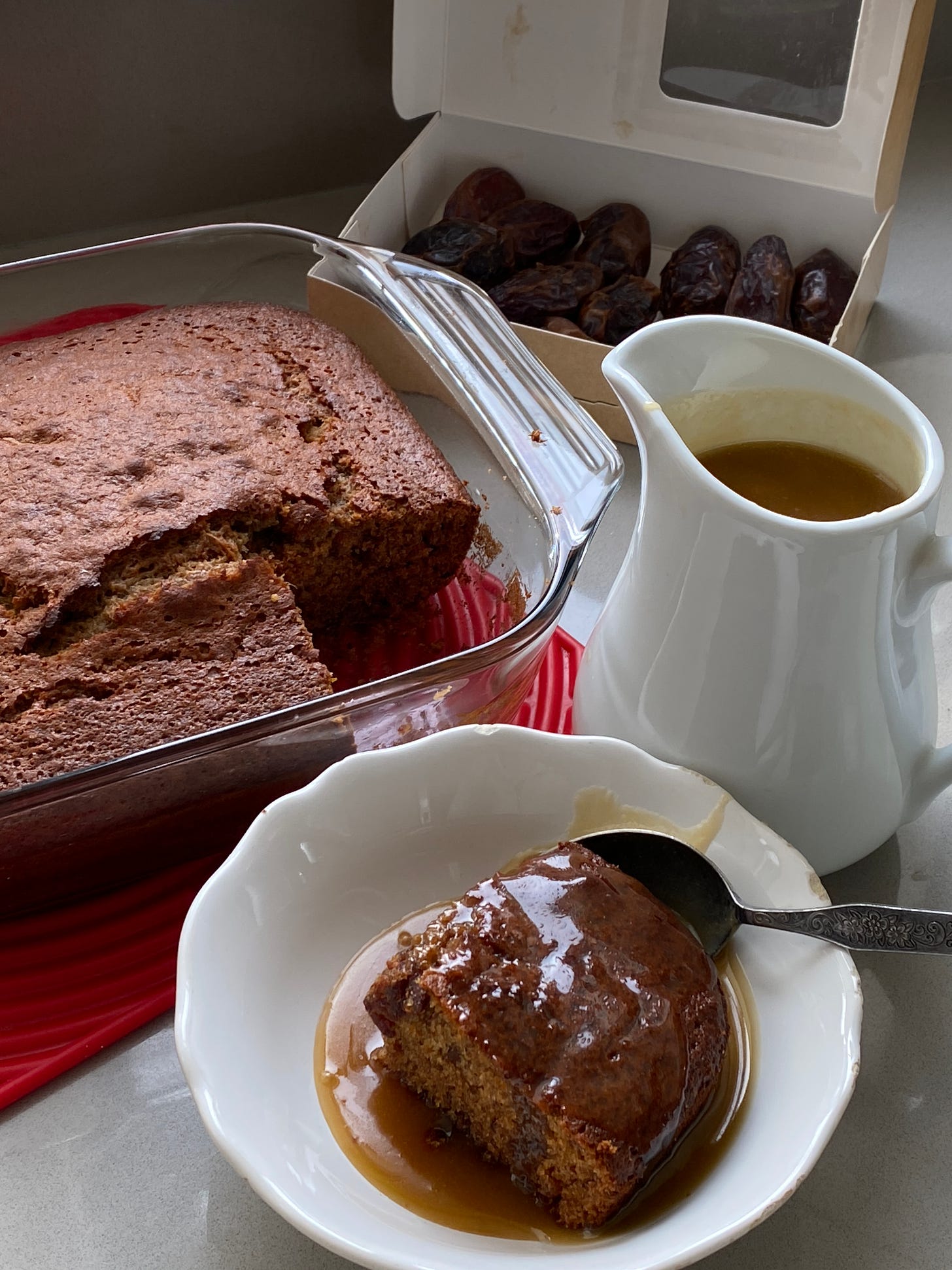 Sticky Toffee Pudding with a Toffee Sauce served in a white dish.