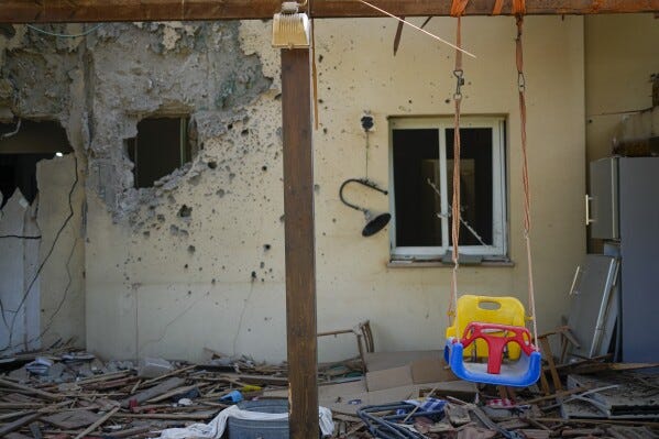 A children's swing hangs in a house damaged by Hamas militants is seen in Kibbutz Be'eri, Israel, Saturday, Oct. 14, 2023. The kibbutz was overrun by Hamas militants from the nearby Gaza Strip on Cot.7, when they killed and captured many Israelis. (AP Photo/Ariel Schalit)