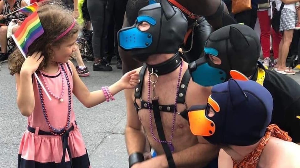 Pride Parade Cape Town child interacting with BDSM people in puppy masks