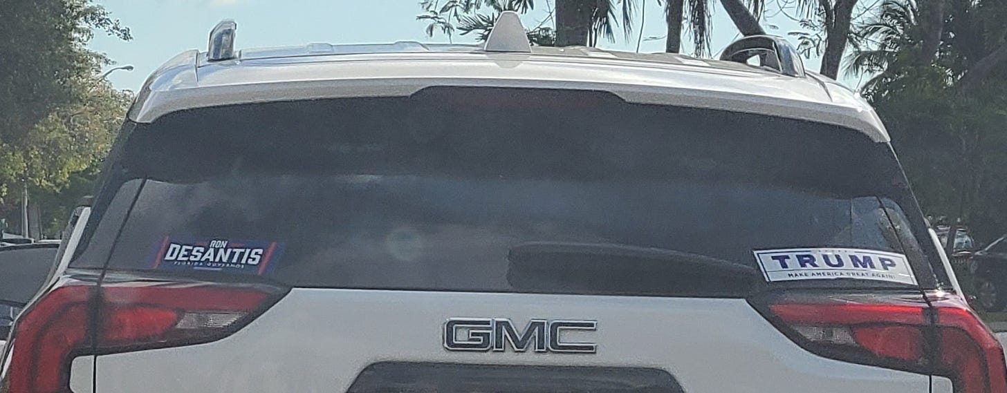 GMC SUV with both Trump and DeSantis bumper stickers.