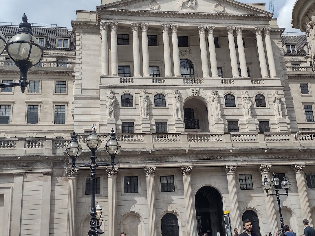 Tall stone building that looks like three mansions staked on each other, with columns