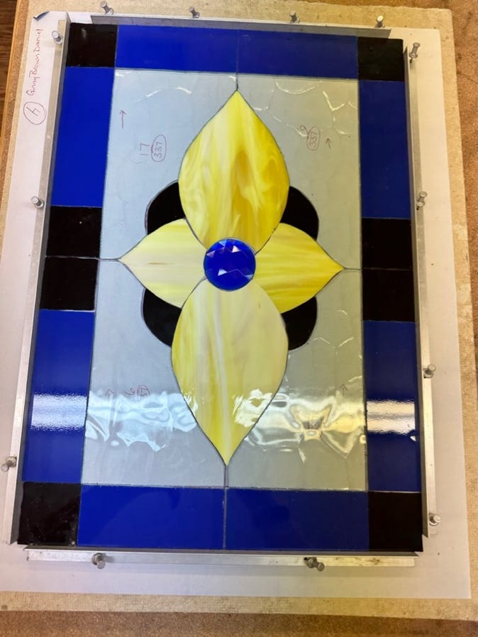 A stained glass window with a flower

Description automatically generated