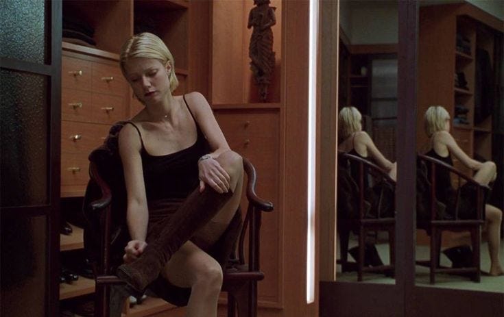 This may contain: a woman sitting in a chair with her legs crossed