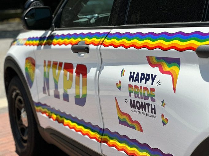 NYPD rainbow police car that says "happy pride month all colours are beautiful" inside a rainbow box