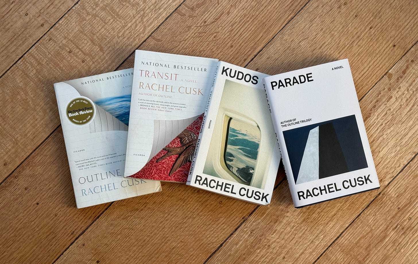 hardwood floor background. Book spread of Outline by Rachel Cusk, Transit by Rachel Cusk, Kudos by Rachel Cusk, and Parade by Rachel Cusk