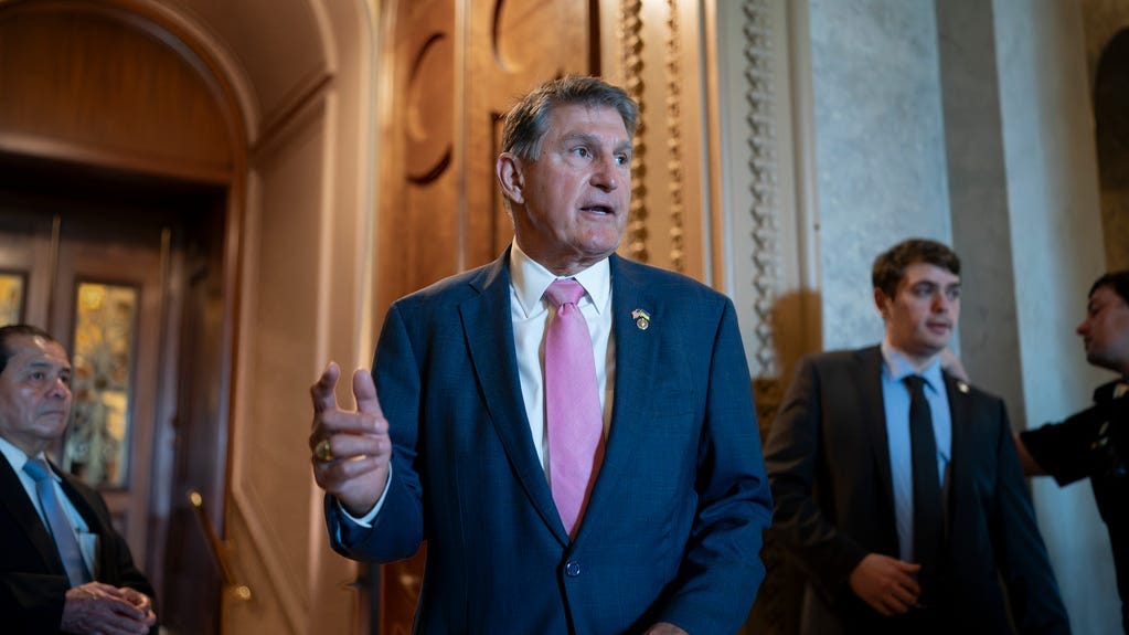 Sen. Joe Manchin, D-W.Va., chairman of the Senate Energy and Natural Resources Committee, speaks to a colleague just outside the chamber, at the Capitol in Washington, Tuesday, June 13, 2023.