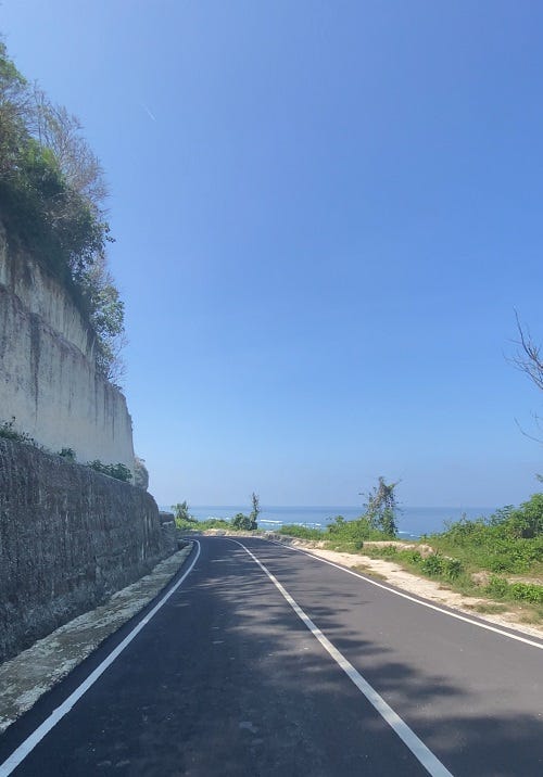 The road opens and runs along the cliffs with ocean views