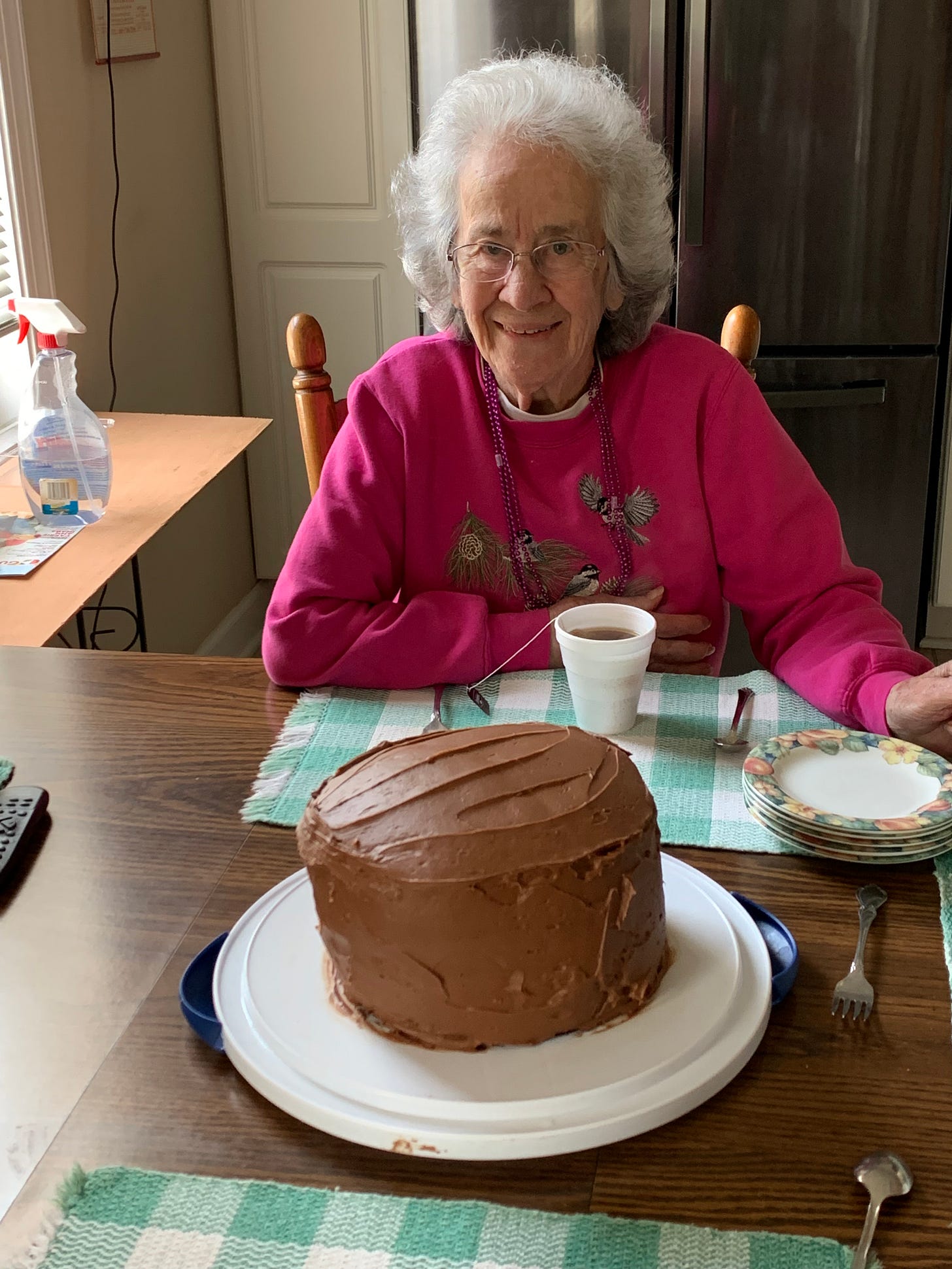 Mom at the kitchen table with chocolate cake.