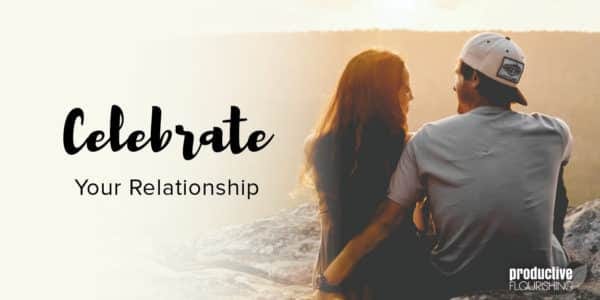 A man and long-haired woman sit on a ledge, back to the camera, as the man holds his hand around her hip. Text Overlay: Celebrate Your Relationship