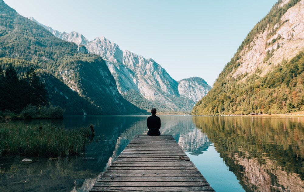 Person meditating on a dock (Credit: Simon Migaj / Unsplash)