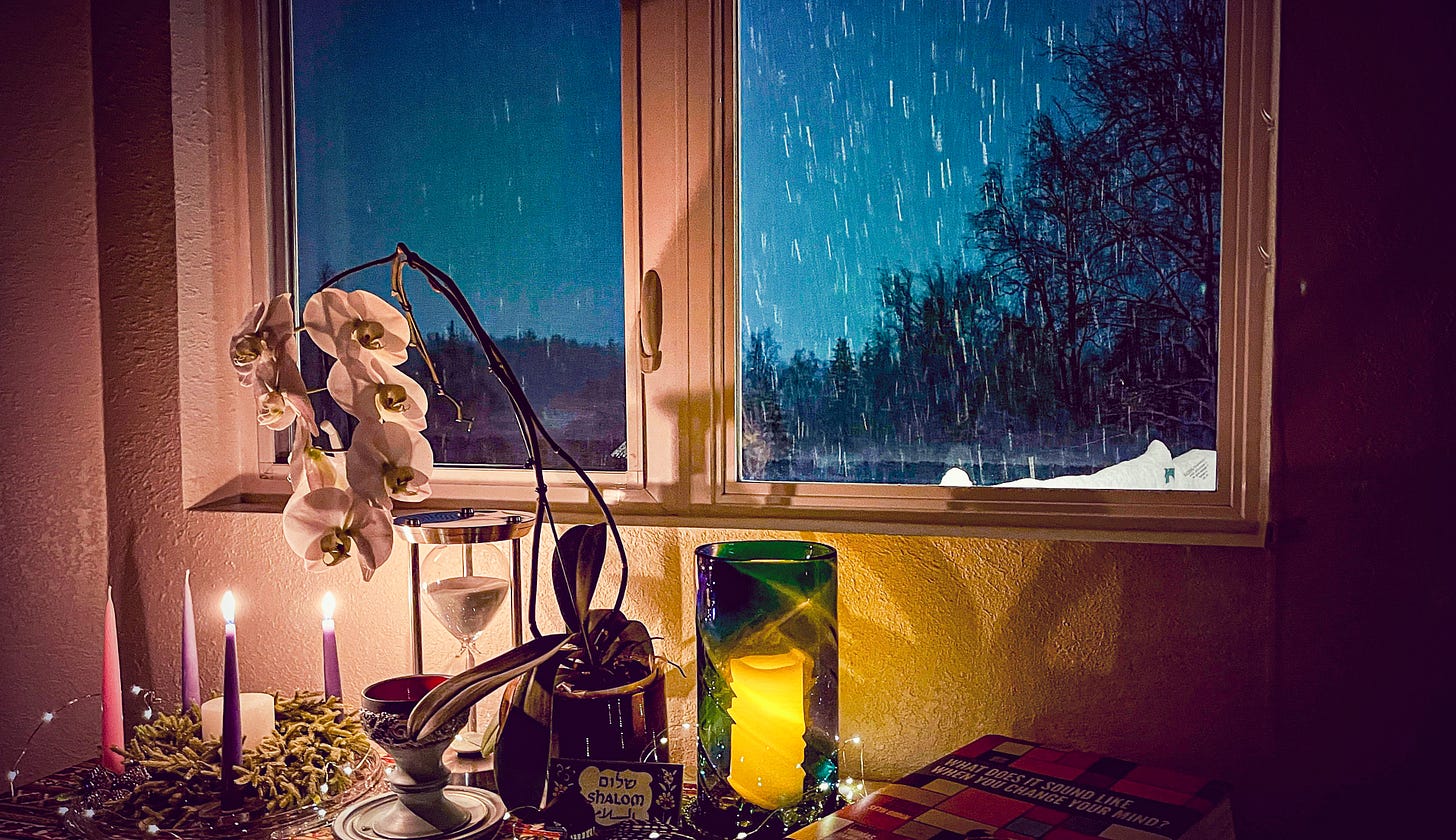 snow outside a window with a candle