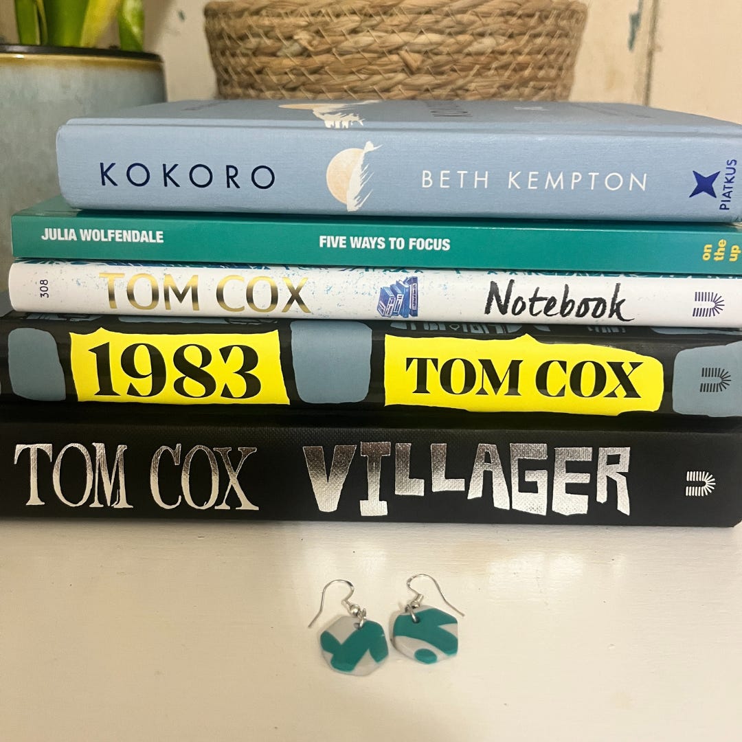 Book stack with the mentioned books along with the earrings which are in front of the stack