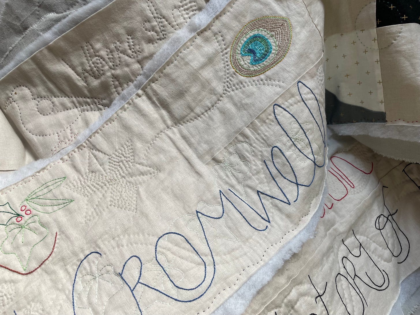 Strips of quilting showing lettering and images of peacock feathers, birds, leaves, star. The word “Cromwell” is visible.