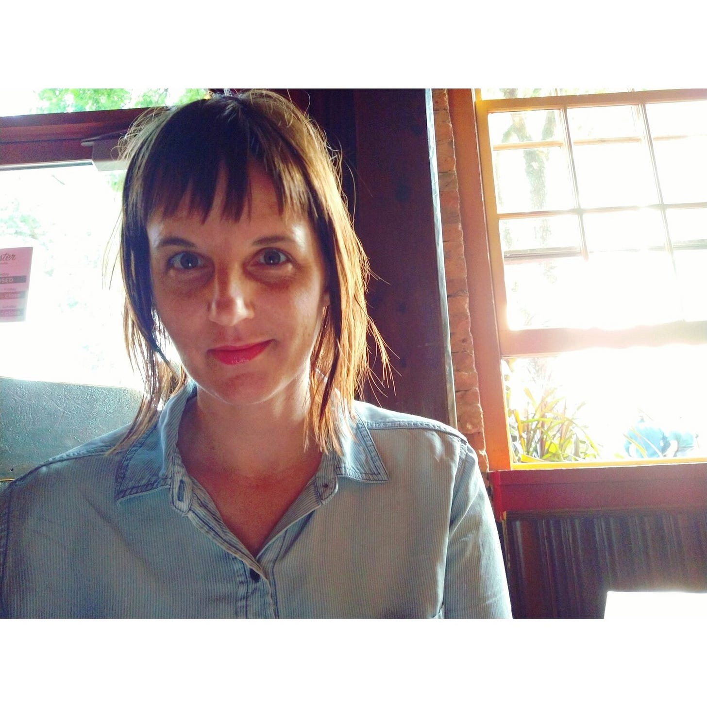 Author Heather Demetrios in front of a bright sunlit window