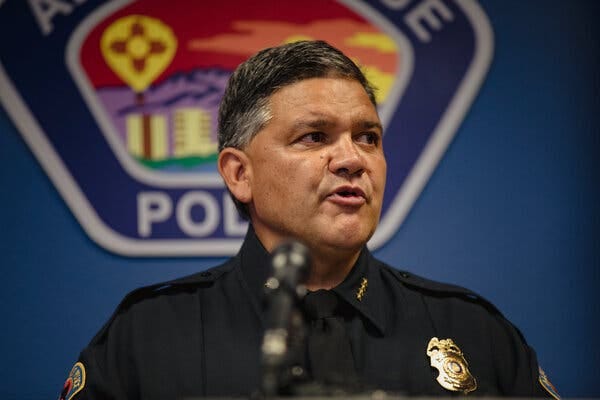 Chief of Police Harold Medina speaking to the media. The seal of the Albuquerque Police Department is seen in the background.