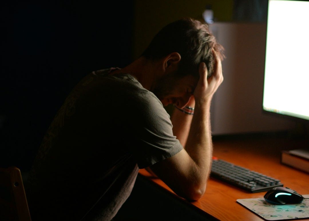 a man sitting at a desk in front of a computer