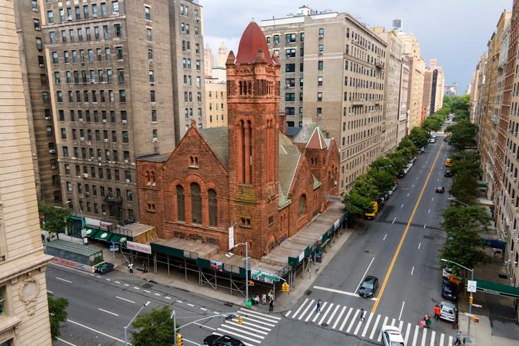 A bird's-eye view of a red brick church on a dense urban block.