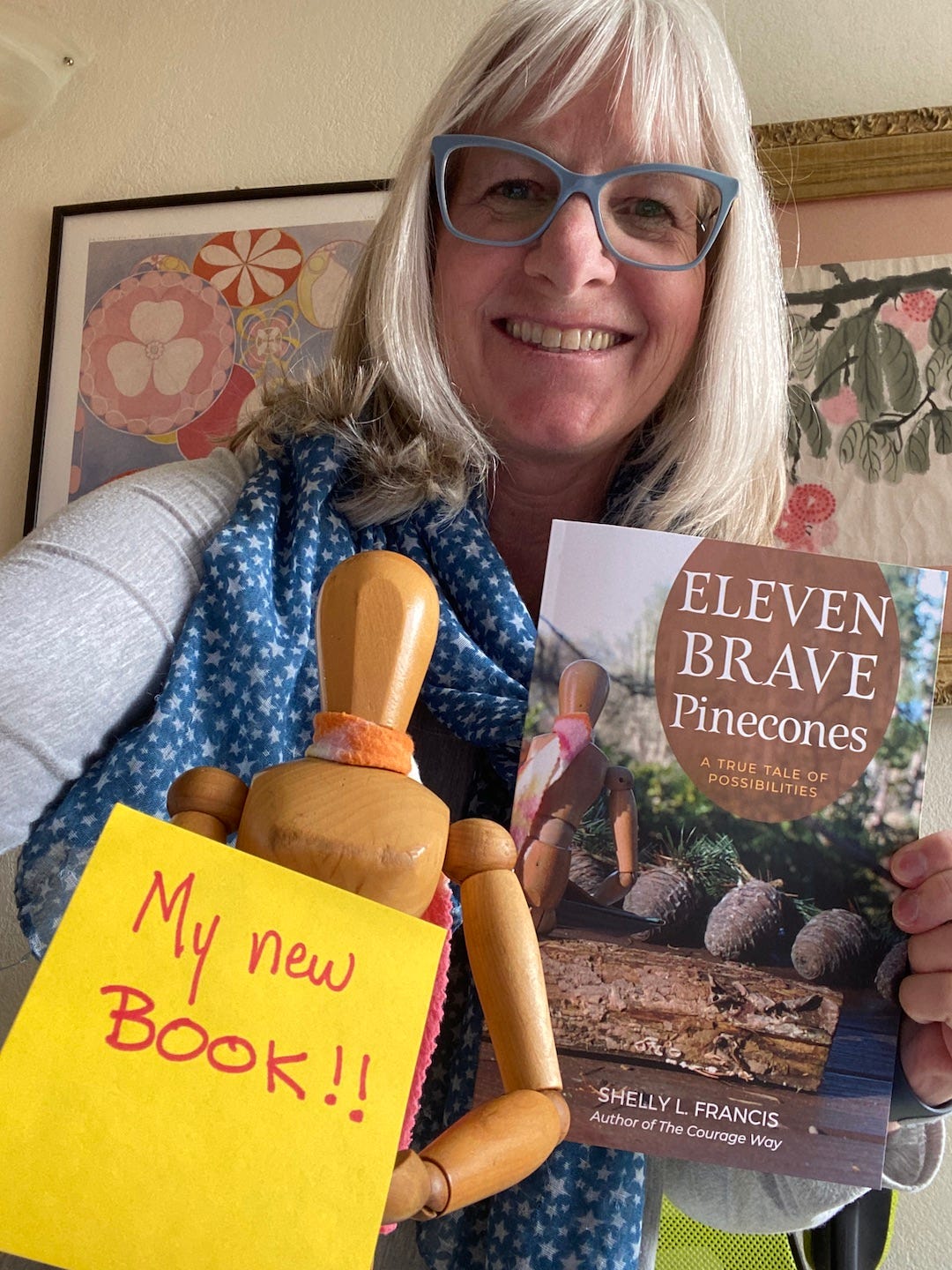 Author Shelly Francis grinning about her new book, shown here, Eleven Brave Pinecones.