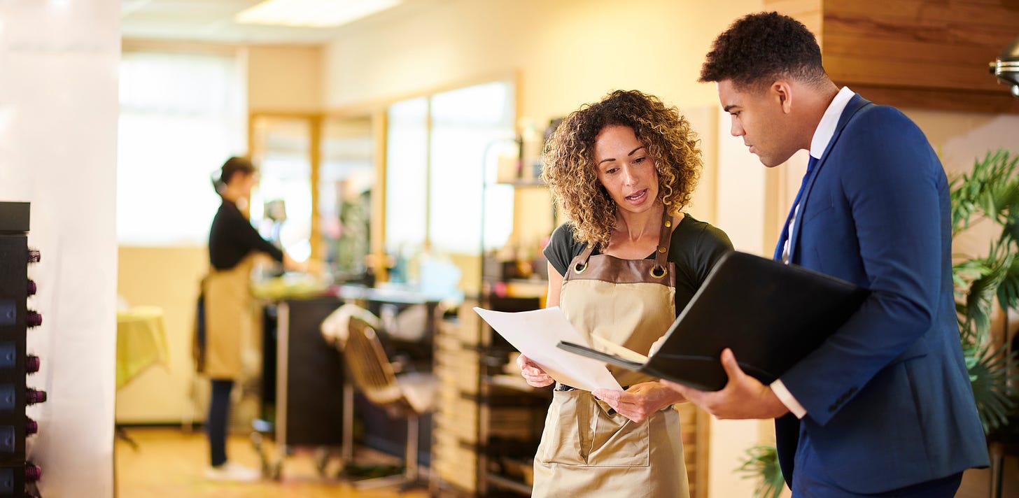 Hair salon owner chatting to a salesman