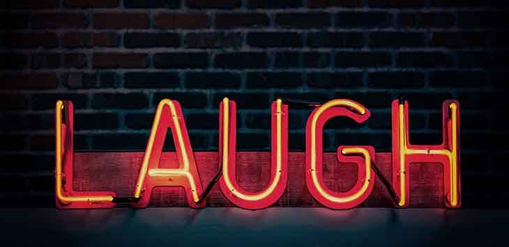 Photo of a neon sign reading "Laugh".