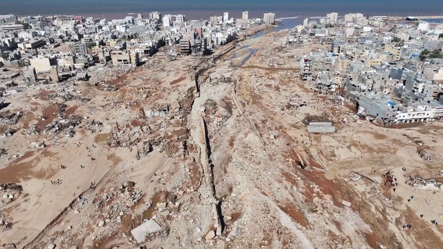 An aerial view of a broad swath of flood-damaged ground in the middle of a coastal city