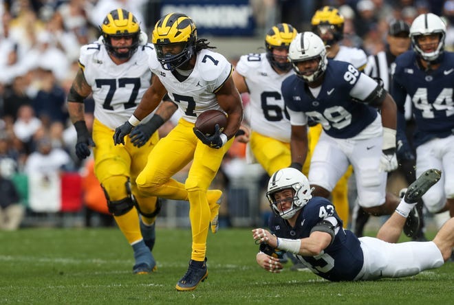 Michigan running back Donovan Edwards (7) runs the ball after breaking a tackle attempt by Penn State linebacker Tyler Elsdon (43) during the second quarter at Beaver Stadium.
