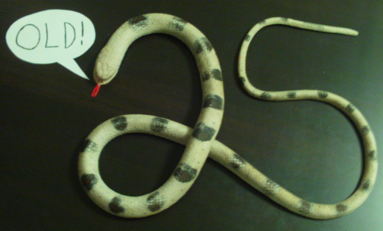 A fake snake, posed in the shape of the number 25, with a speech bubble saying "old!"