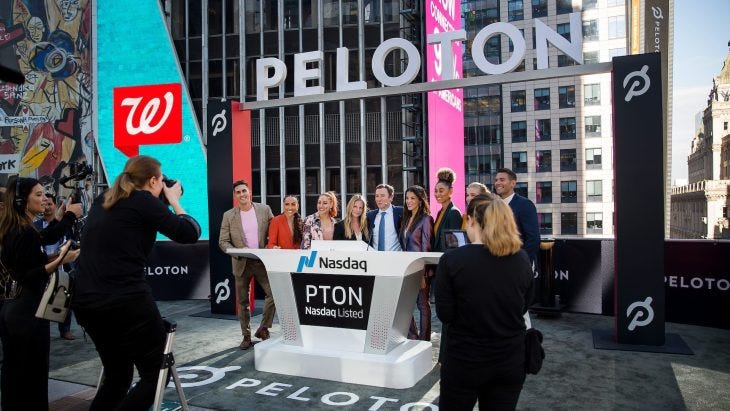 John Foley, co-founder and chief executive officer of Peloton Interactive Inc., center, stands for a photograph with fitness instructors during the company's initial public offering (IPO) at the Nasdaq MarketSite in New York, U.S., on Thursday, Sept. 26, 2019.
