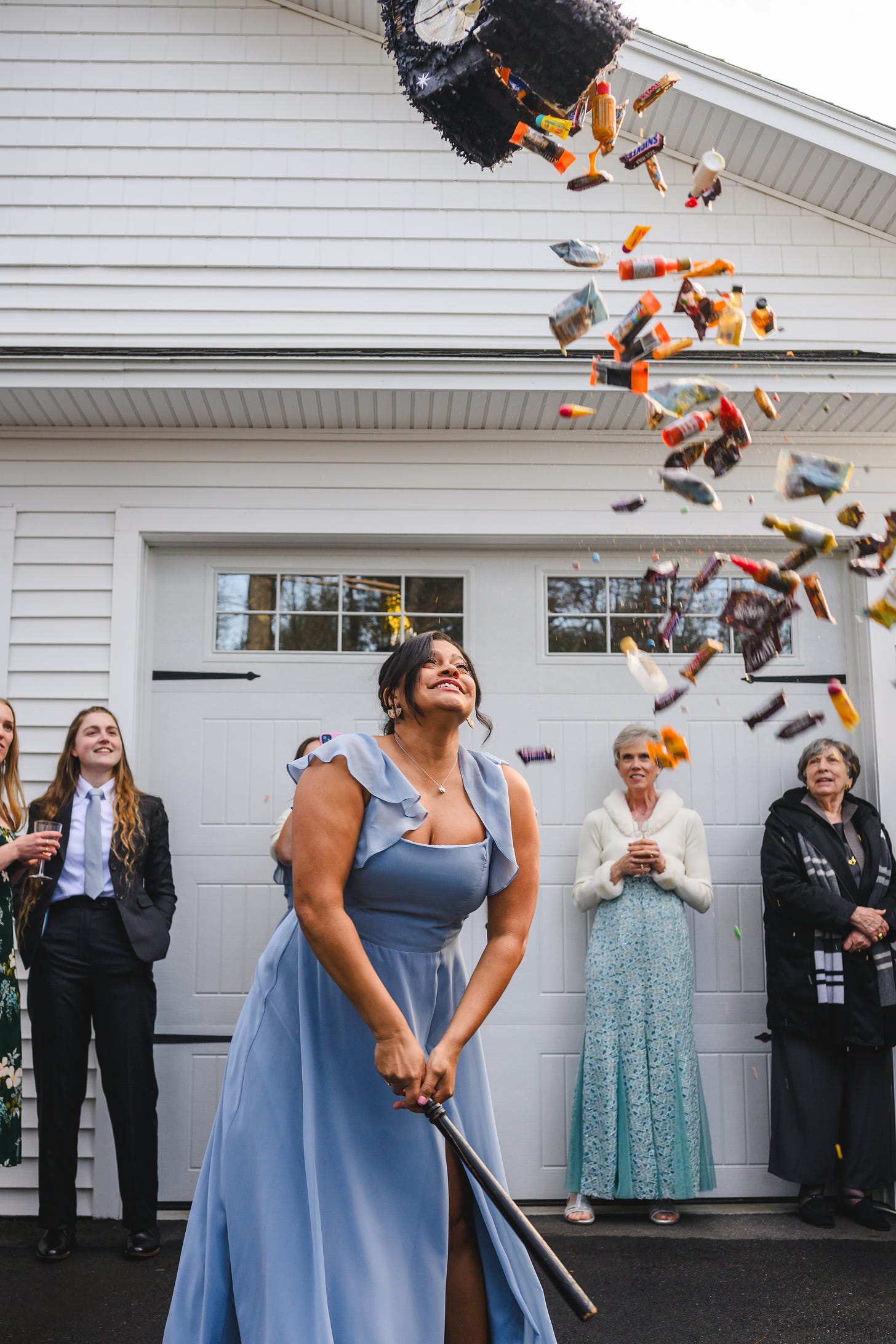 A bridesmaid smashing open a piñata