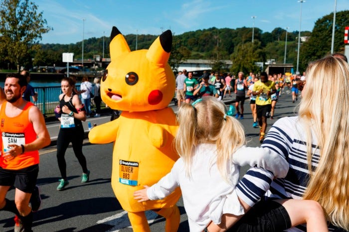 A marathon runner in a costume among a crowd of onlookers