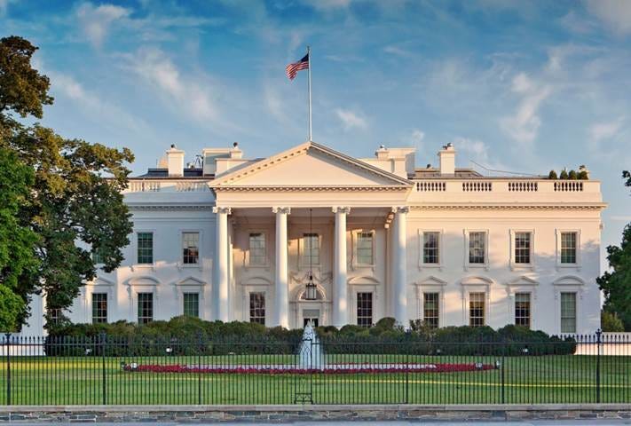 A large white building with a flag on top

Description automatically generated with low confidence