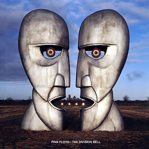 The album cover for Pink Floyd's "The Division Bell", showing two large metallic sculptures facing one another - each looks like a face, but they also look like they could combine into a single face. Behind them is distant lights and buildings, around them is vacant farmland and cloudy blue sky.