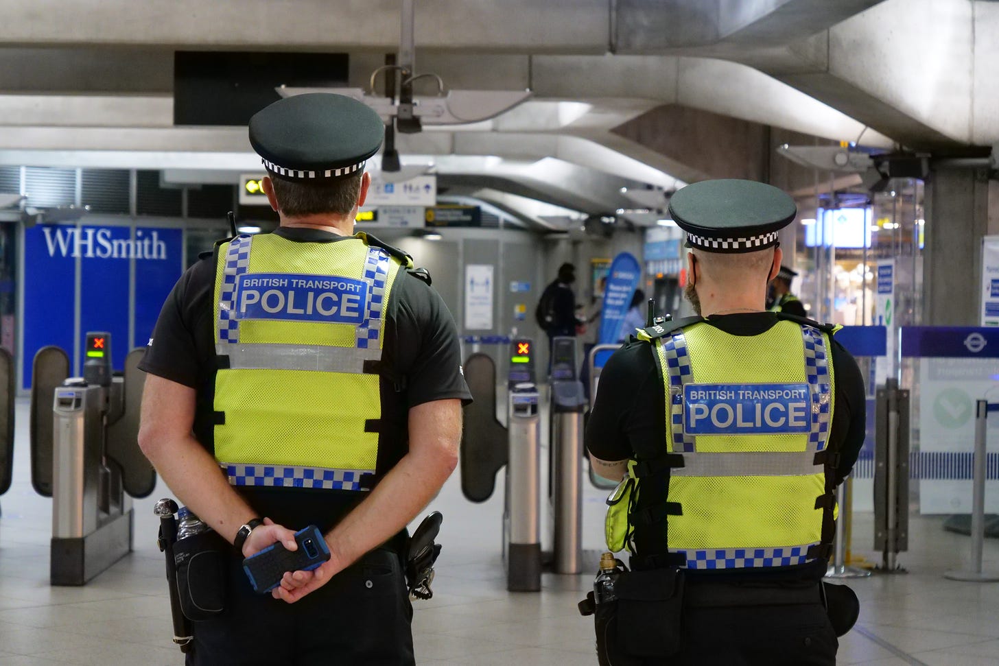 two police officers at the entrance to a tube station