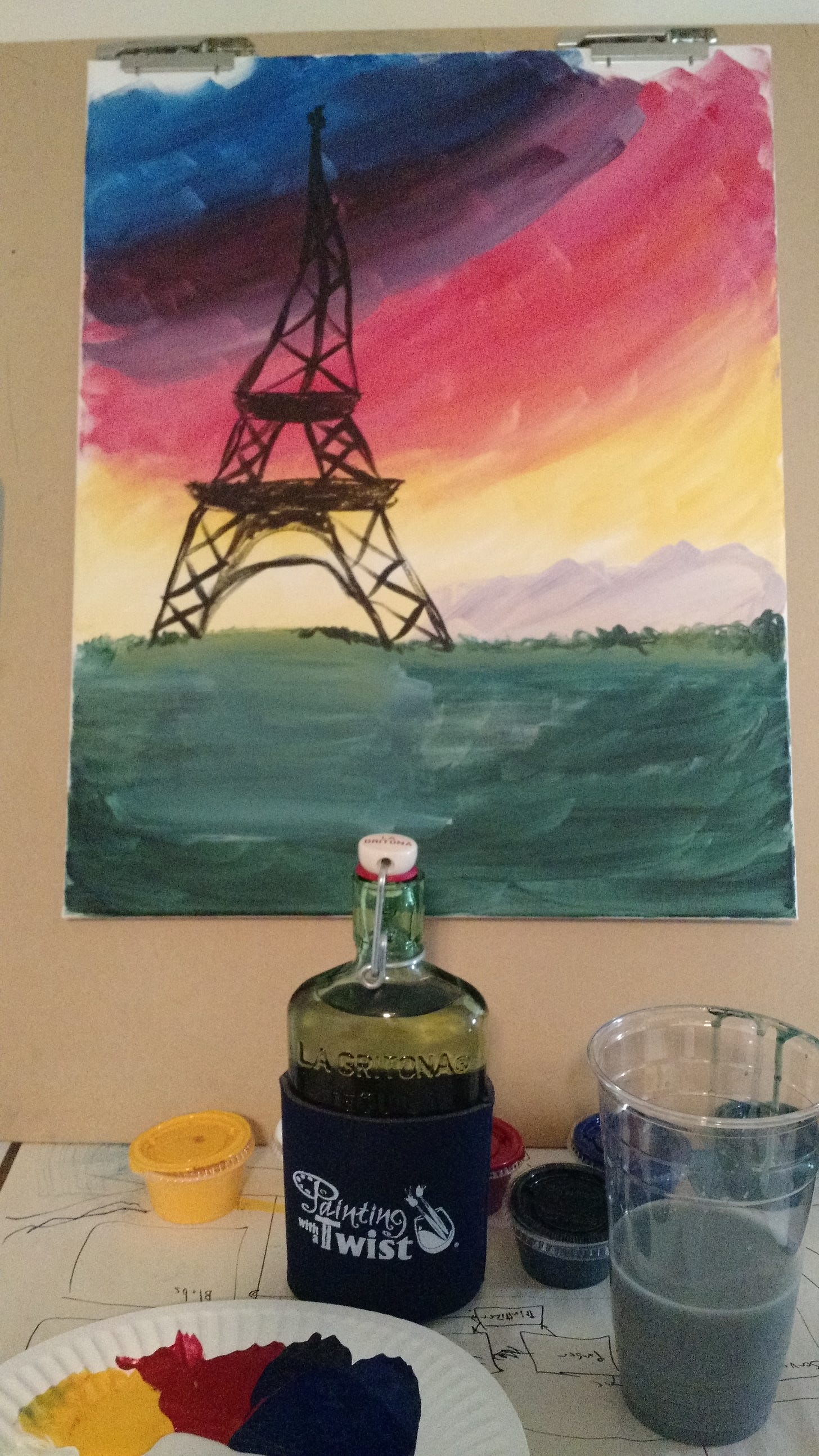 A painting of the eiffel tower, with painting supplies