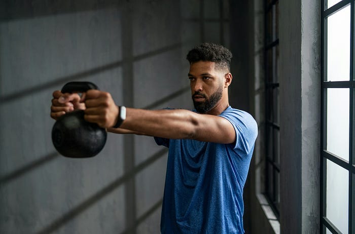 A man working out with kettlebells at the gym. A man working out with kettlebells at the gym.