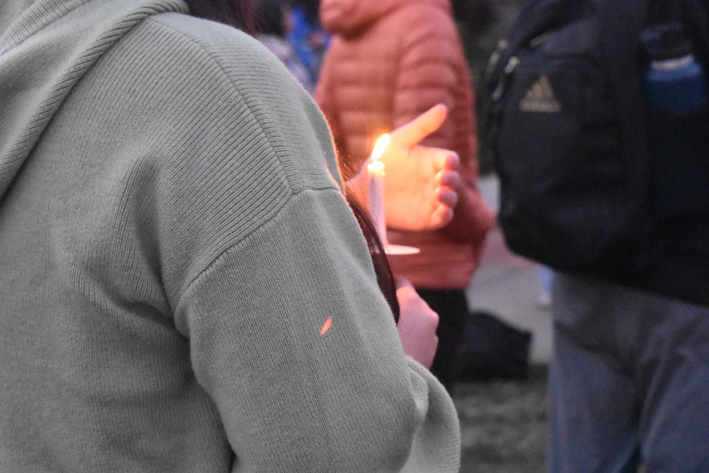 Attendees at the vigil hold candles to remember the lives lost during the Israel-Hamas war.