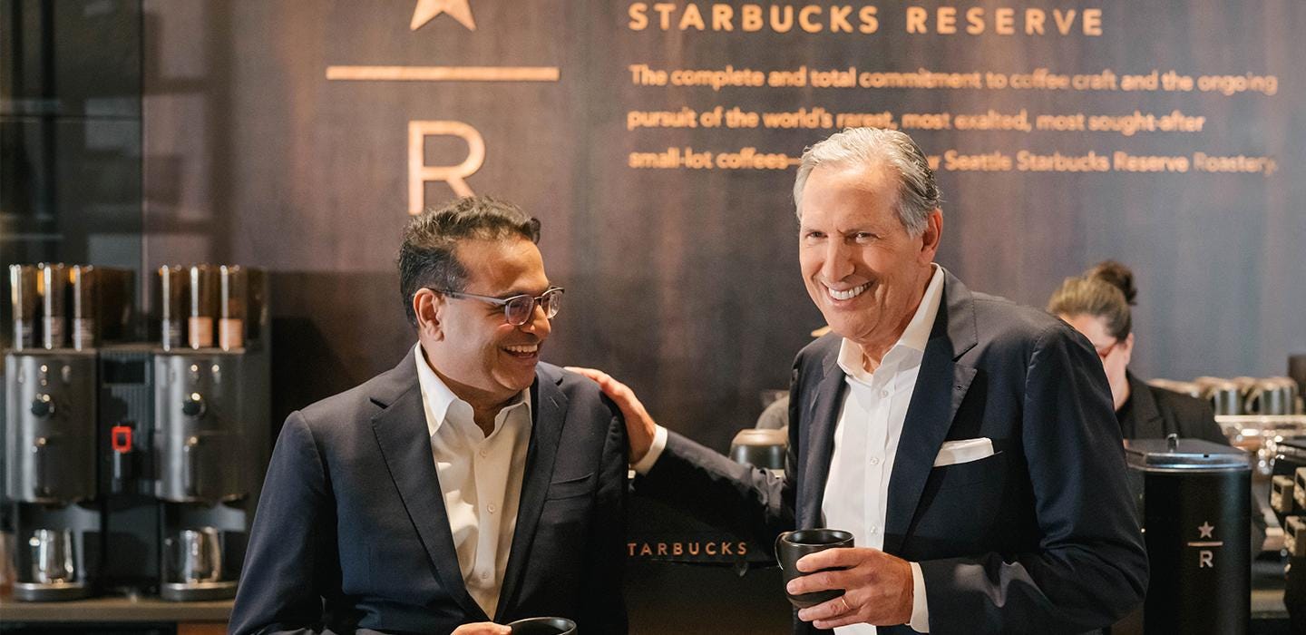 From left to right: Laxman standing with smiling Howard inside Starbucks Reserve store