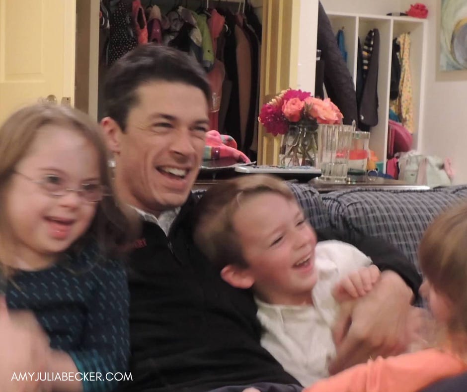 Peter sits in the center of the couch, laughing and embracing Penny, William, and Marilee