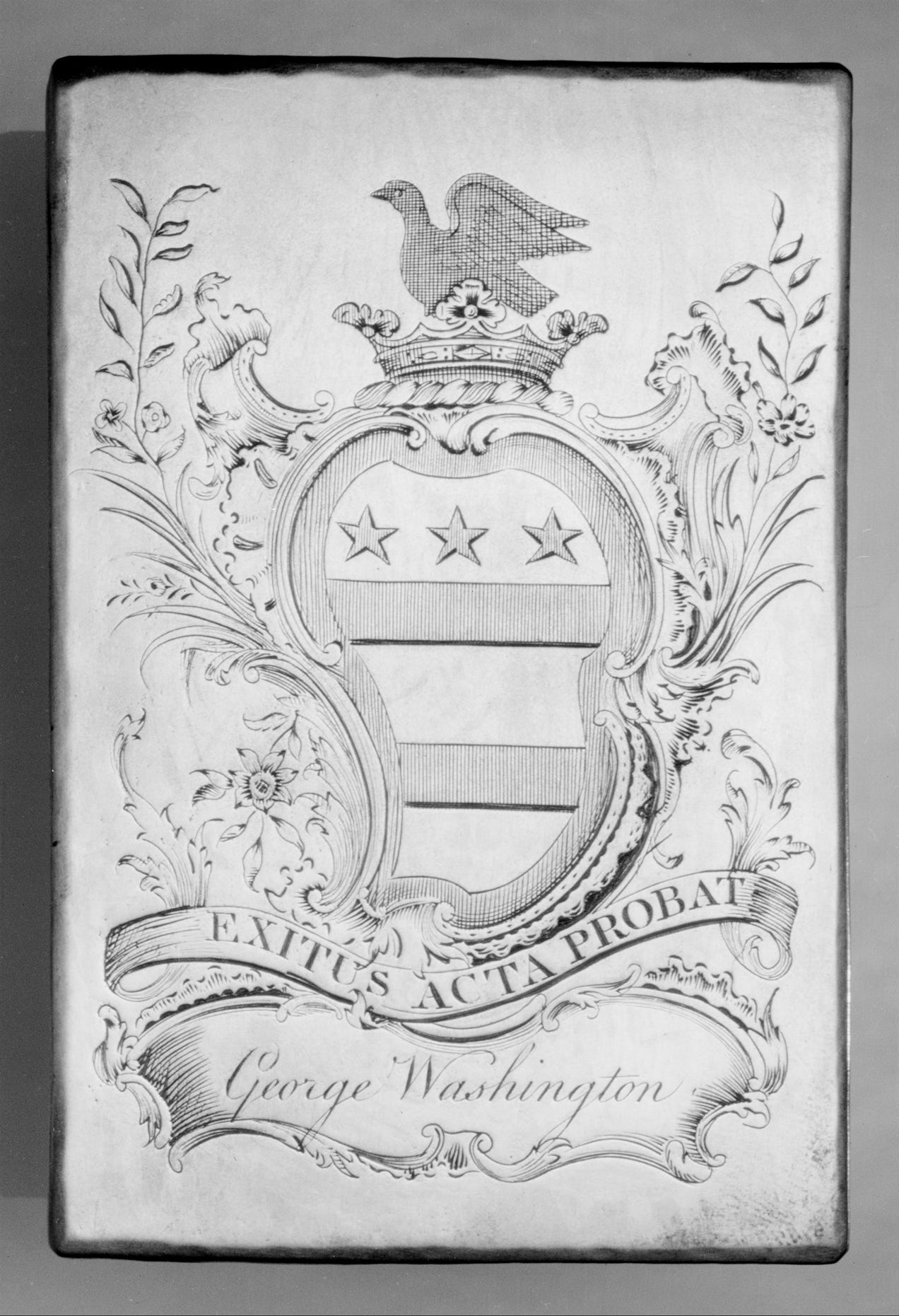 Bookplate of bird atop a shield, surrounded by leaves and flowers, with George Washington's name and motto