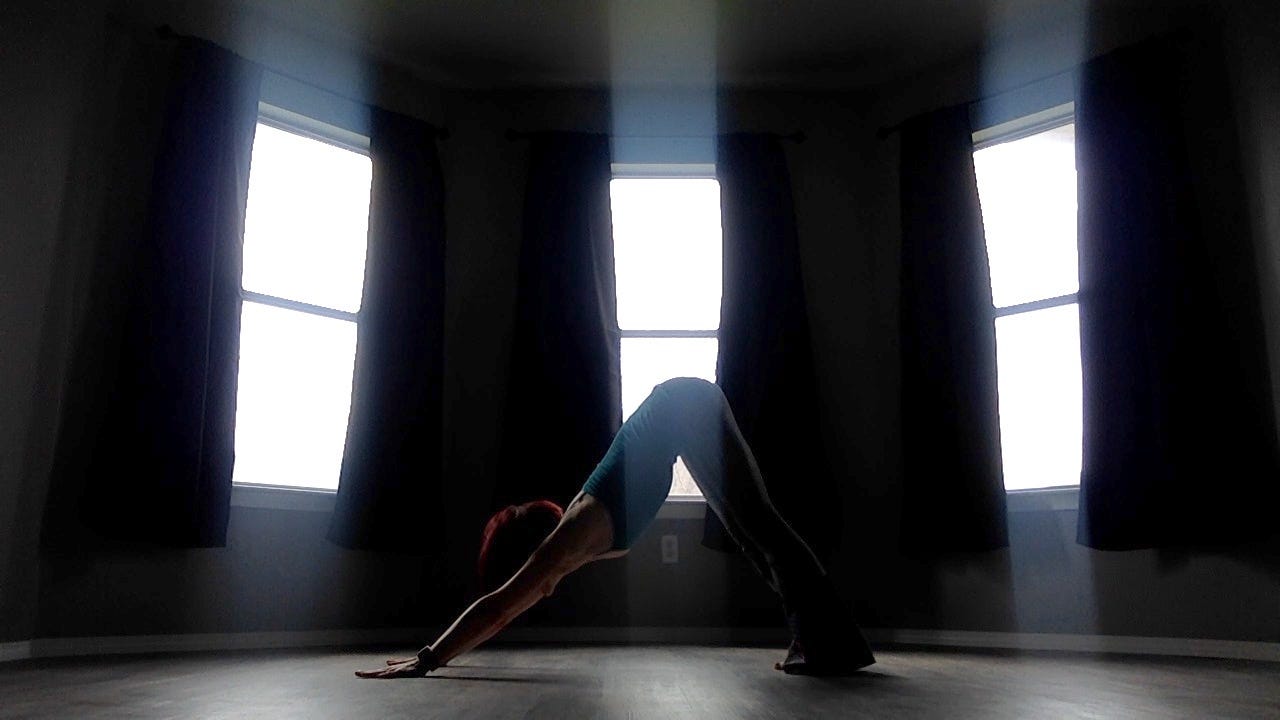 Photo of Lyric doing a downward dog pose in their old bedroom. 