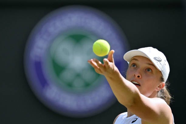 Poland's Iga Swiatek serves to France's Alize Cornet during their women's singles tennis match on the sixth day of the 2022 Wimbledon Championships...