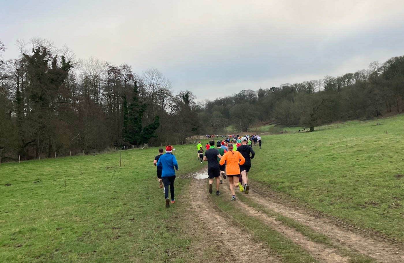 Runners on a path on a camber, with puddles ahead