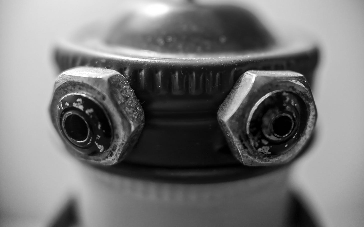 Macro shot of the metal nuts that serve as a tiny metal roboto's eyes