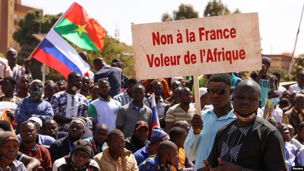 A protester holds a sign that reads, 'No to France the thief of Africa' as people gather to show their support to Burkina Faso's new military leader Ibrahim Traore, in Ouagadougou, Burkina Faso, Jan. 20, 2023. 