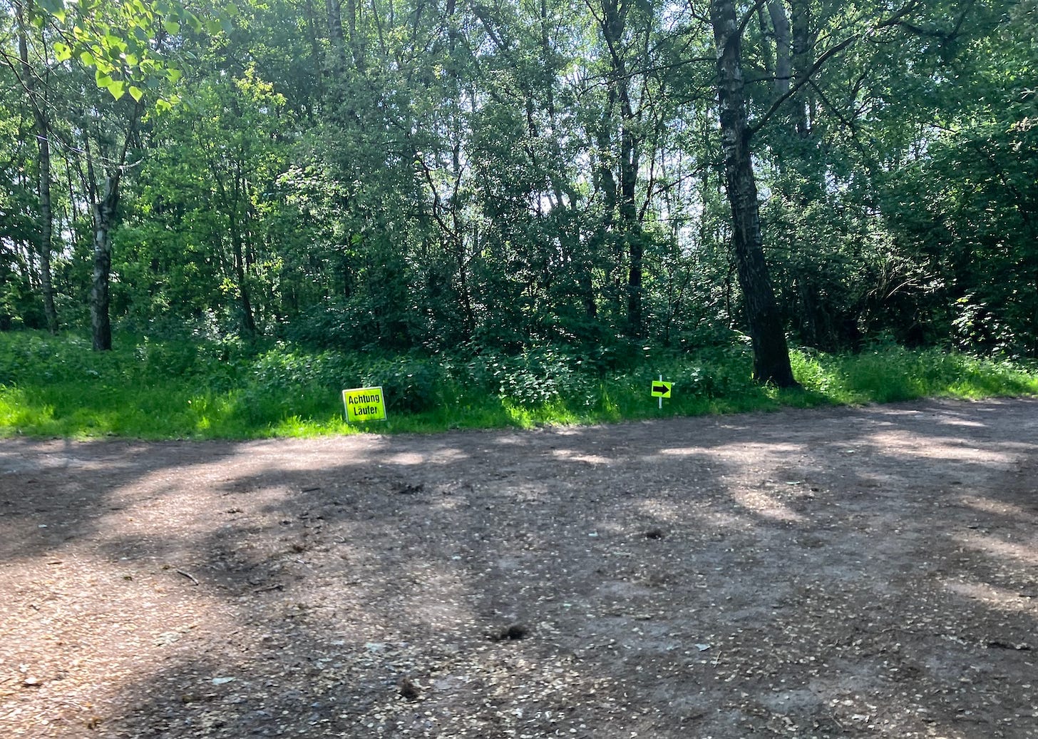 Caution runners and direction sign next to a wide path